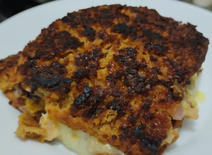 Una foto de Sandwich🍗en pan🥐de plátano relleno de pollo🧀y queso🫓🧀🧅