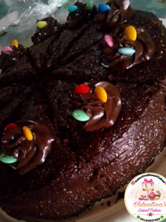 Una foto de Torta húmeda de chocolate, decorada y rellena de chocolate