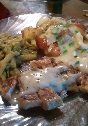 A picture of Sean's-Leek white gravy smothered pork chops w/ Roasted Red Potatoes.