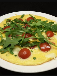 Una foto de Torti pizza de cherrys y rúcula