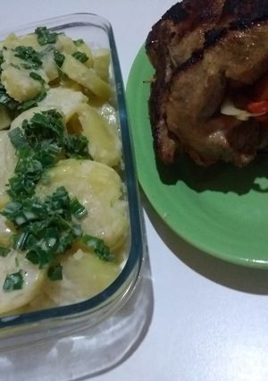 Una foto de Bondiola de cerdo rellena y papas con crema y verdeo