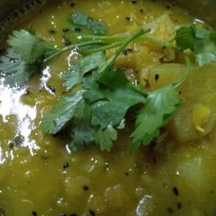 A picture of Yellow peas daal with slice of radish.
