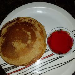 A picture of Pancake with strawberry syrup.