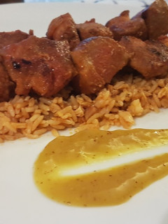 Una foto de Pinchos morunos caseros sobre arroz al curry