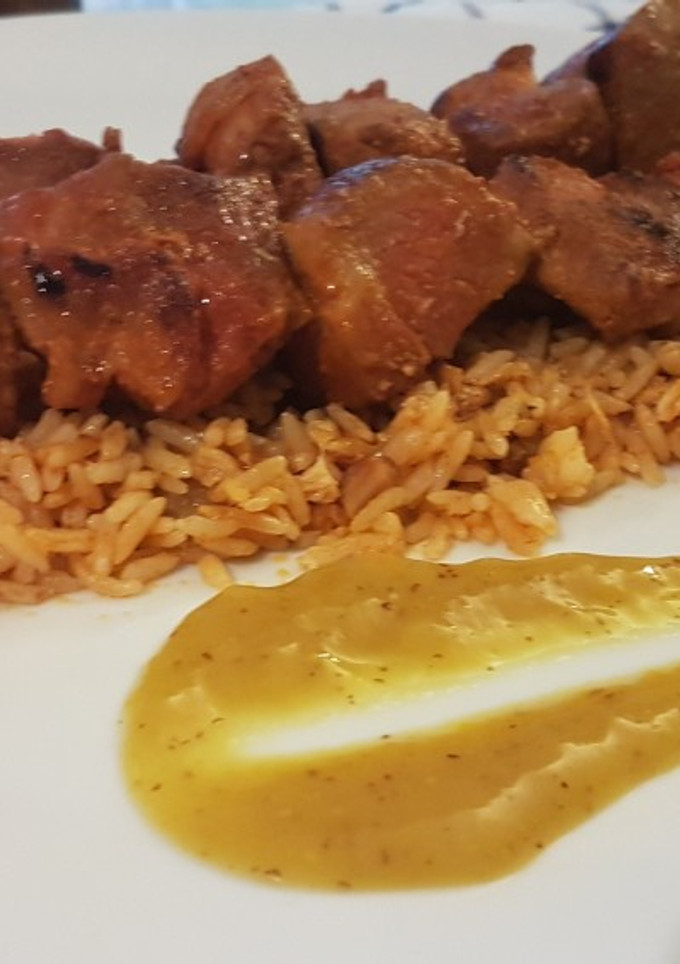 Una foto de Pinchos morunos caseros sobre arroz al curry
