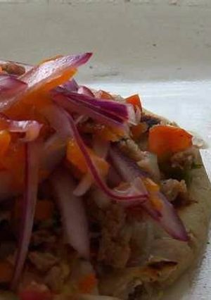 Una foto de Tostada vegana de ceviche de soya texturizada y cebolla morada desflemada