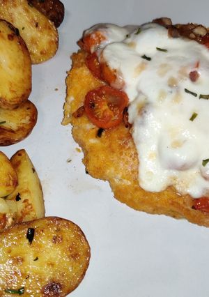 A picture of Mozzarella chicken with sautéed tomato's.