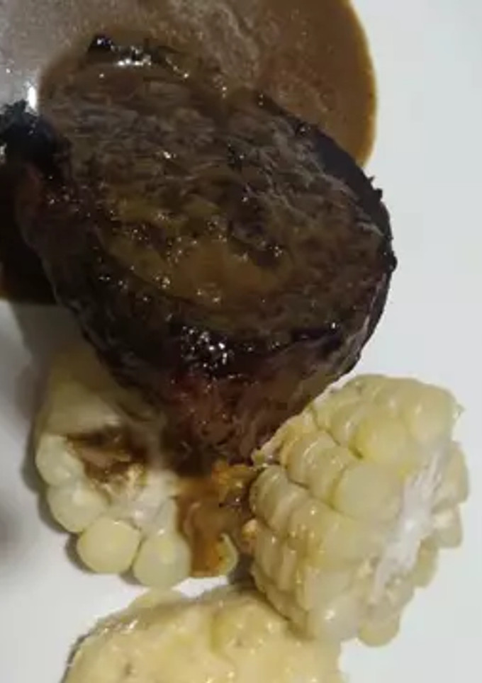 Una foto de Lomo de res en salsa de epazote, elotes horneados y puré de plátano