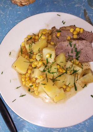 Una foto de Colita cuadril con papas y maíz en wok
