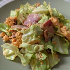 A picture of Fried cabbage and bacon with egg.