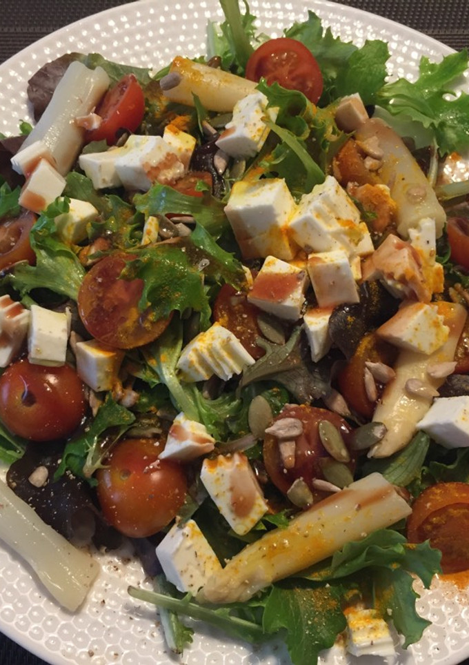 Una foto de Brotes Verdes con tomates, espárragos, queso fresco y cúrcuma