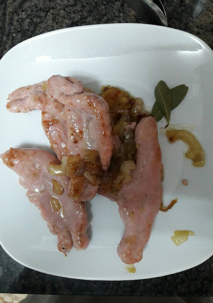 Una foto de Salchichas de pavo y pollo con cebolla caramelizada y cerveza