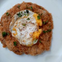 Crispy pattie with leftover bread crumbs top with fried egg A picture of Crispy pattie with leftover bread crumbs top with fried egg.