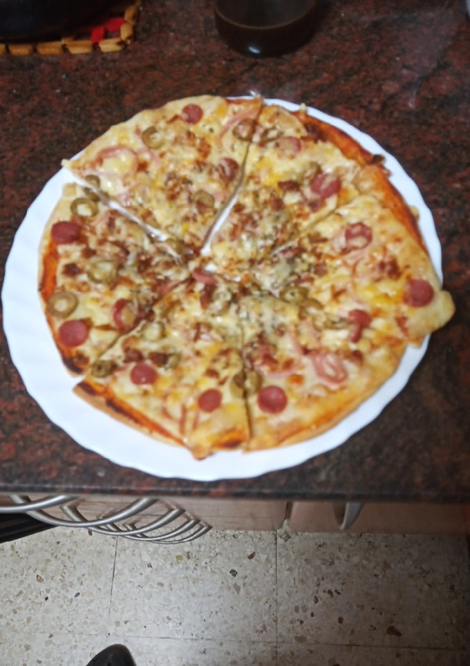 Una foto de Pizza de jamón cocido, salchicha y aceitunas