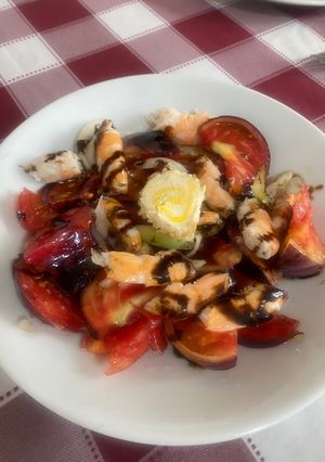 Una foto de Ensalada de tomate azul y rulo de cabra