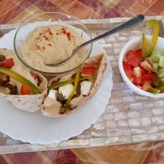 A picture of #feast Pita Pocket filled with salad,cottage cheese and Hummus.