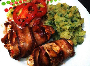 Una foto de Rollo de pollo envuelto en tocineta y verduras con puré de papa y ensalada