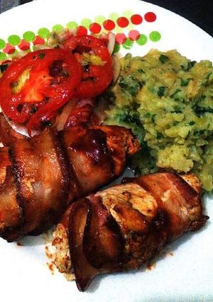 Una foto de Rollo de pollo envuelto en tocineta y verduras con puré de papa y ensalada