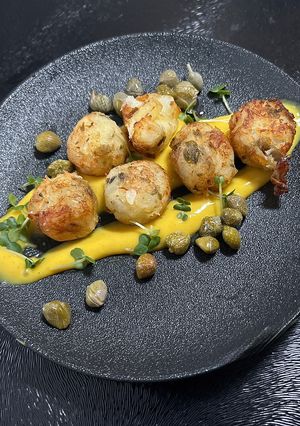 A picture of Crab balls with curry mayonnaise and capers.