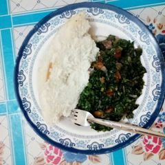 A picture of Ugali with mixed greens.