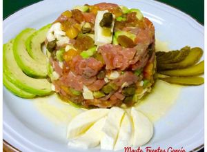 Una foto de Tartar de trucha ahumada, aguacate, kaki, y mozzarella