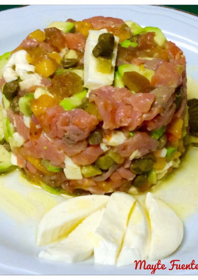 Una foto de Tartar de trucha ahumada, aguacate, kaki, y mozzarella