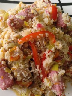 Una foto de Cous cous con calabaza, calabacín, setas, pimientos y salchichas