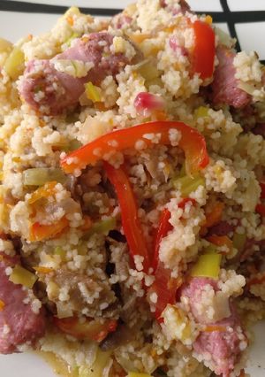 Una foto de Cous cous con calabaza, calabacín, setas, pimientos y salchichas