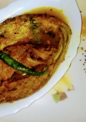 A picture of Kalo Jera Pabda Macher Jhol / Black Cumin Seeds Paste Curry.