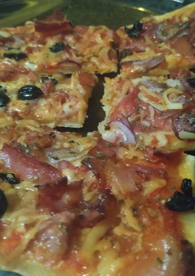 Una foto de Pizza extrafina sabrosa y sin levadura con cerveza