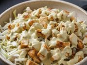 Una foto de ensalada con salsa de yogur