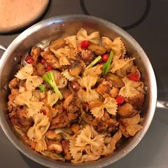 A picture of Chicken thigh, pasta and veggie leftovers.