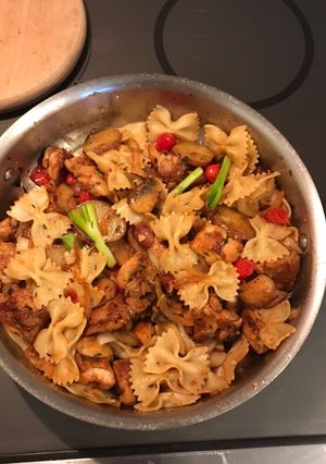 A picture of Chicken thigh, pasta and veggie leftovers.