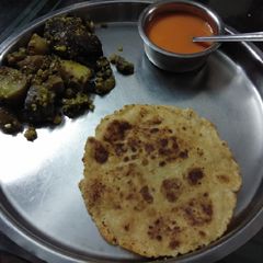 A picture of Undhiyu bhakhri and mango juice frozen.
