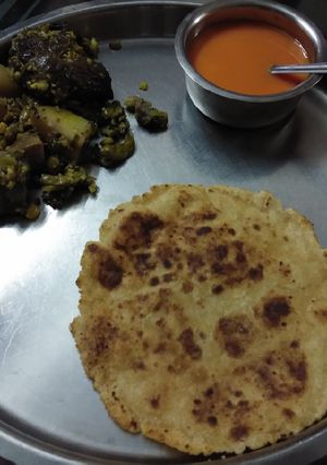 A picture of Undhiyu bhakhri and mango juice frozen.