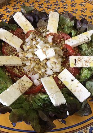Une photo de Salade aux tomates, feta, oignon italien et pistaches