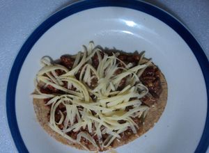 Una foto de Huarache  asado de birria de pollo adobada al tequila con queso tipo San Diego.  Jalisco México