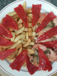 Una foto de Filetes de lomo en salsa verde con patatas fritas y pimientos de piquillo
