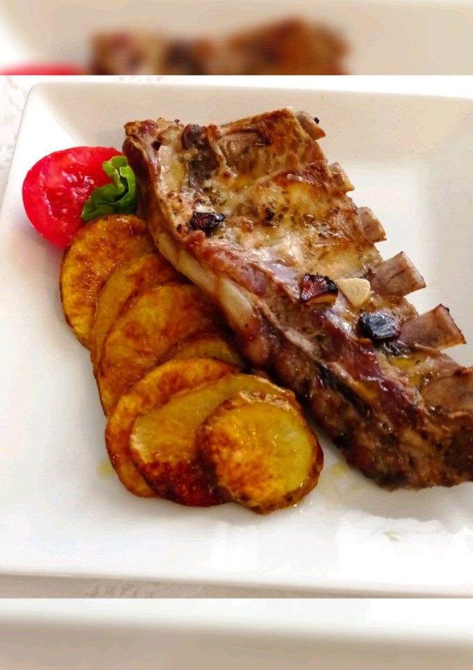 Una foto de Costillas de cerdo al ajo y limón con patatas al horno