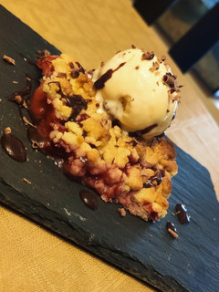 Una foto de Crumble de fresas con helado de vainilla y chocolate