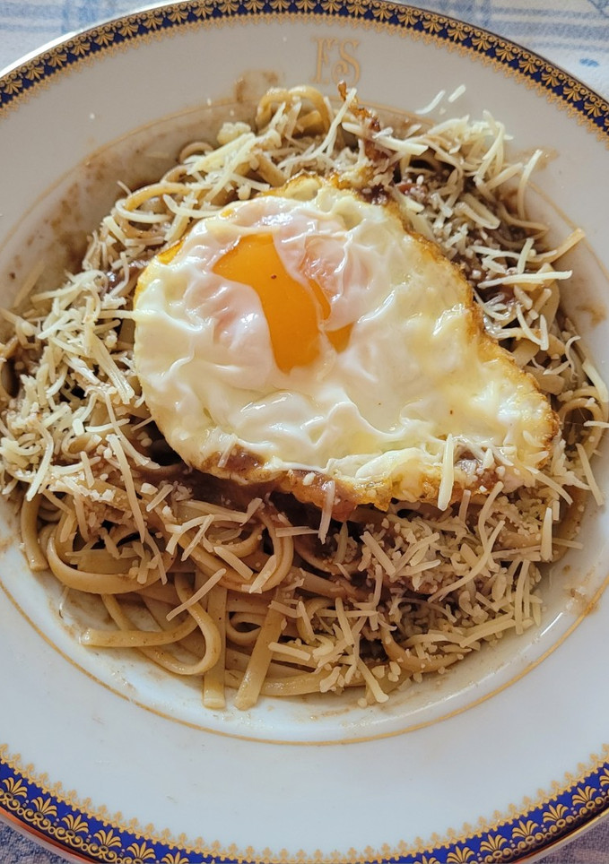 Una foto de Tallarines con salsa de rabo de toro, queso parmesano y huevos fritos