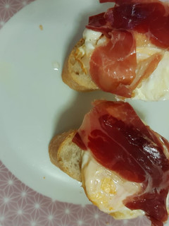 Una foto de Montaditos de pan con huevo frito y jamón serrano