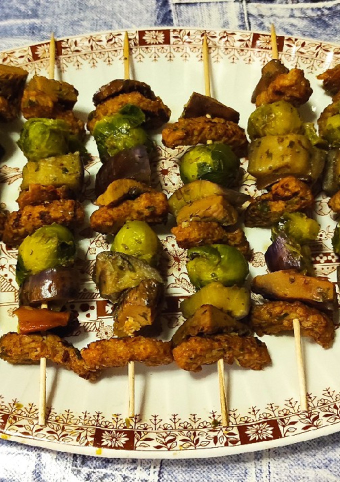 Una foto de Brochetas de bocaditos braseados, rovellones, berenjena y coles Bruselas con majao ajo y perejil