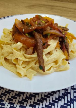 Una foto de Pasta huancaína con ternera saltado peruana