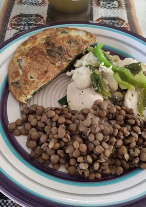 Una foto de Pollo con cebollín y pimentón, con tortilla de acelga y lentejas