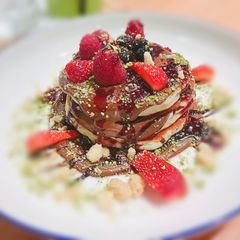 A picture of Wheat flour pancakes with maple syrup and some chocolate dip.