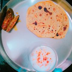 A picture of Achari Parantha with lauki ka raita & mango pickle.