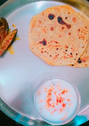A picture of Achari Parantha with lauki ka raita & mango pickle.