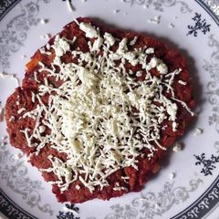 A picture of Beetroot Chilla topped with Cheese.