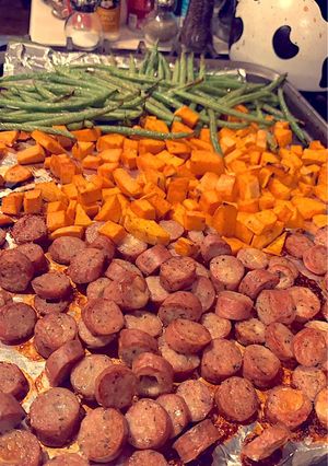 A picture of Roasted chicken sausage, sweet potatoes, and fresh green beans.